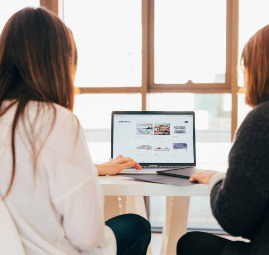 two womens behind computer